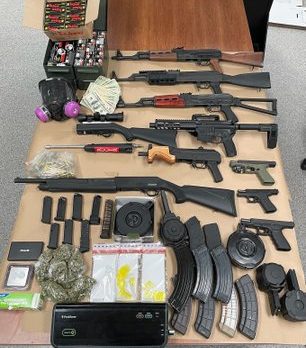 Several search warrants executed resulting in many weapons, drugs & money being seized.
